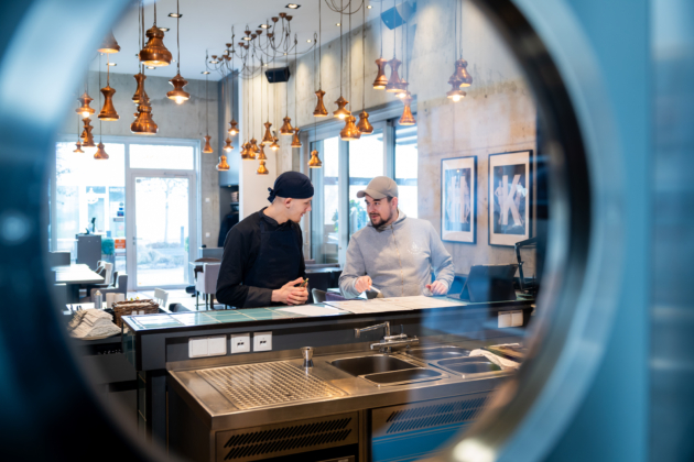 Jan Matthiesen (re.), Inhaber des Restaurants „Hansekai“, zusammen mit Koch-Azubi Leon Scheller bei einer Besprechung.