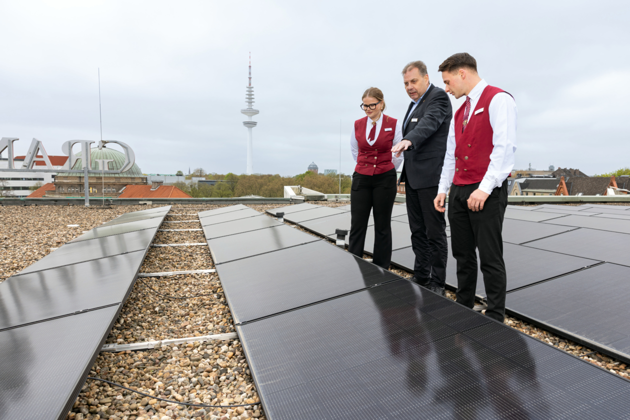 Viele Stunden haben die beiden Grand-Elysée-Azubis und Energie-Scouts Marlene Wiener und David Heinen an ihrem Solarenergieprojekt gearbeitet. Gemeinsam mit dem Technischen Leiter des Hotels Thomas Westphal (Mi.) begutachten sie die Solarpanels auf dem Hoteldach.